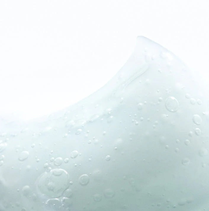 Close-up of water droplets on a glass surface with a light gray background