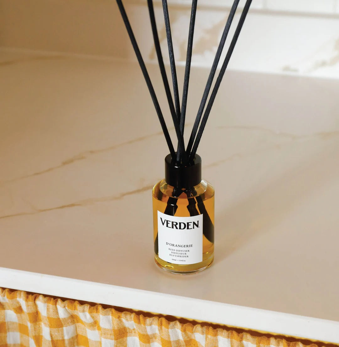 Verden diffuser bottle with black sticks on a beige surface