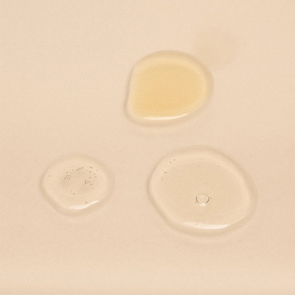 Three droplets of liquid on a beige surface